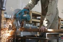 AL ASAD, Iraq – Lance Cpl. Patrick R. Dewey, a 22-year-old machinist and Seattle native with Combat Logistics Battalion 2, 2d Force Service Support Group (Forward), cuts support posts for a cable trailer as the four-Marine machinist and welding shop custom fabricates the trailer. The shop creates, repairs and fabricates metal items to suit the needs of Marines throughout Western Iraq. (Photo by Cpl. John E. Lawson Jr.)
